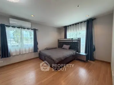 Spacious bedroom with modern decor and large windows for natural light