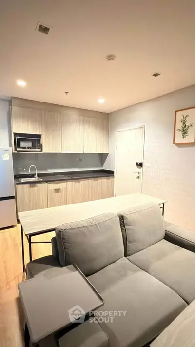 Modern open-layout kitchen and living room with sleek design and cozy ambiance.