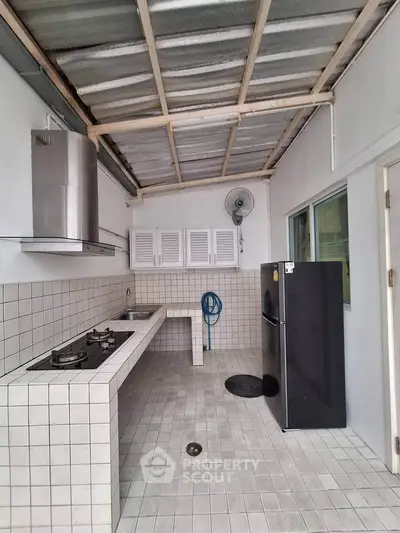 Spacious open-layout kitchen with modern appliances and tiled flooring, perfect for culinary enthusiasts.