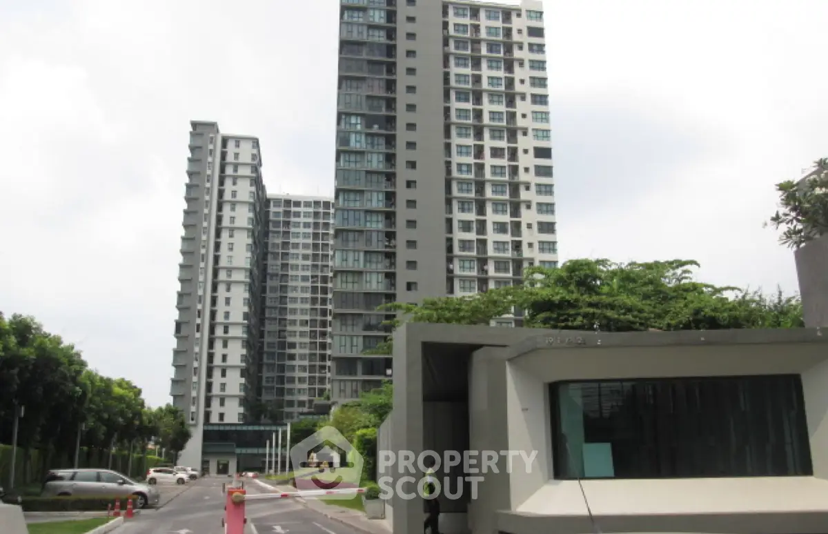 Modern high-rise residential building with lush greenery and secure entrance.