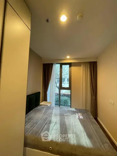 Cozy bedroom with large window and modern decor in a stylish apartment.