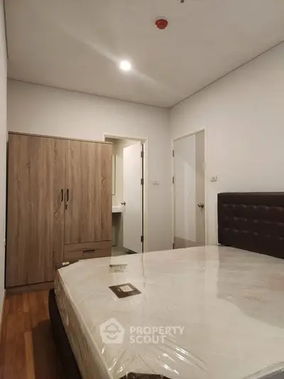 Modern bedroom with wooden wardrobe and comfortable bed in a cozy apartment.