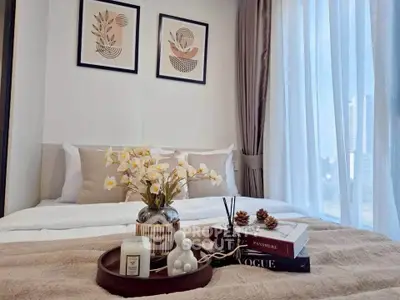 Cozy bedroom with elegant decor, featuring a plush bed, stylish artwork, and a serene city view through large windows.