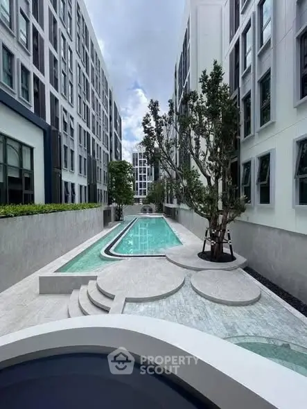 Modern apartment complex with sleek pool and contemporary architecture.