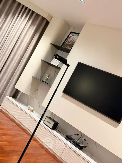 Modern living room with sleek TV setup and stylish shelving, featuring elegant hardwood flooring and luxurious curtains.