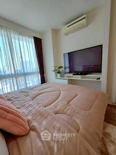 Cozy bedroom with large window, air conditioning, and modern TV setup.