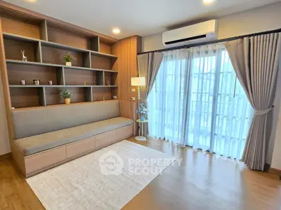 Modern living room with built-in shelving and large window for natural light.