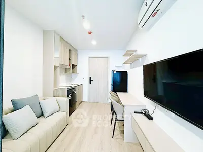 Modern living room with sleek furniture and wall-mounted TV in a stylish apartment.