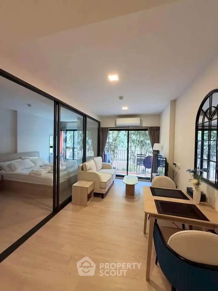 Modern open-plan living room with glass partition and balcony view