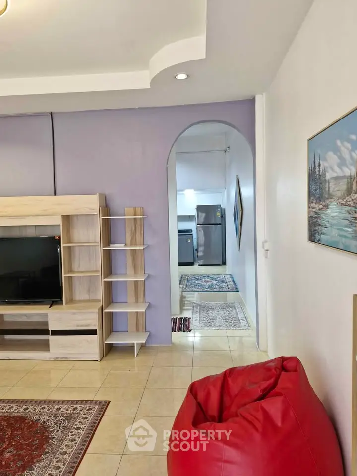 Spacious living room with modern decor and open view to kitchen area.