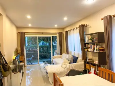 Spacious living room with cozy seating and garden view, perfect for relaxation and entertaining.
