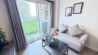 Charming living room with cozy sofa and balcony view, perfect for relaxation and comfort.