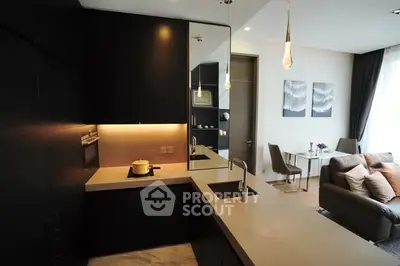 Modern open-layout kitchen with sleek design and cozy living area in luxury apartment.