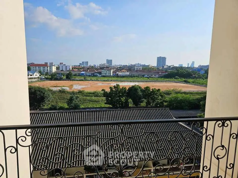 Scenic balcony view overlooking cityscape and open field