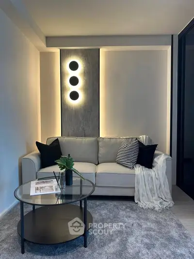 Modern living room with stylish sofa, elegant lighting, and chic decor for a cozy ambiance.