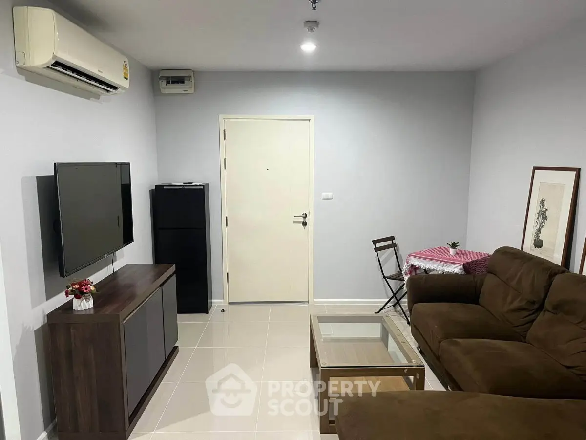 Cozy living room with modern furniture and wall-mounted TV in a stylish apartment.