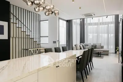 Luxurious open-plan living and dining area with modern decor and elegant lighting