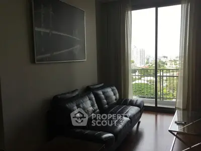 Modern living room with leather sofa and city view from large window.