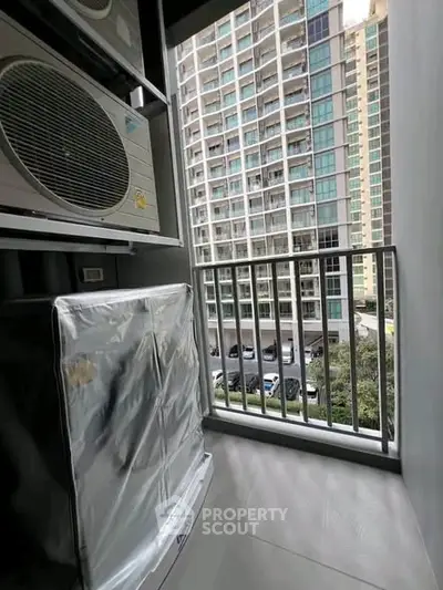 Modern apartment balcony with city view and air conditioning unit.