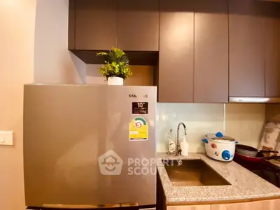 Modern kitchen with stainless steel fridge and compact sink area.