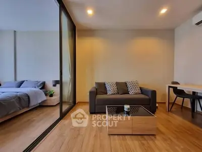 Modern living room with cozy sofa and stylish decor adjacent to a bedroom.