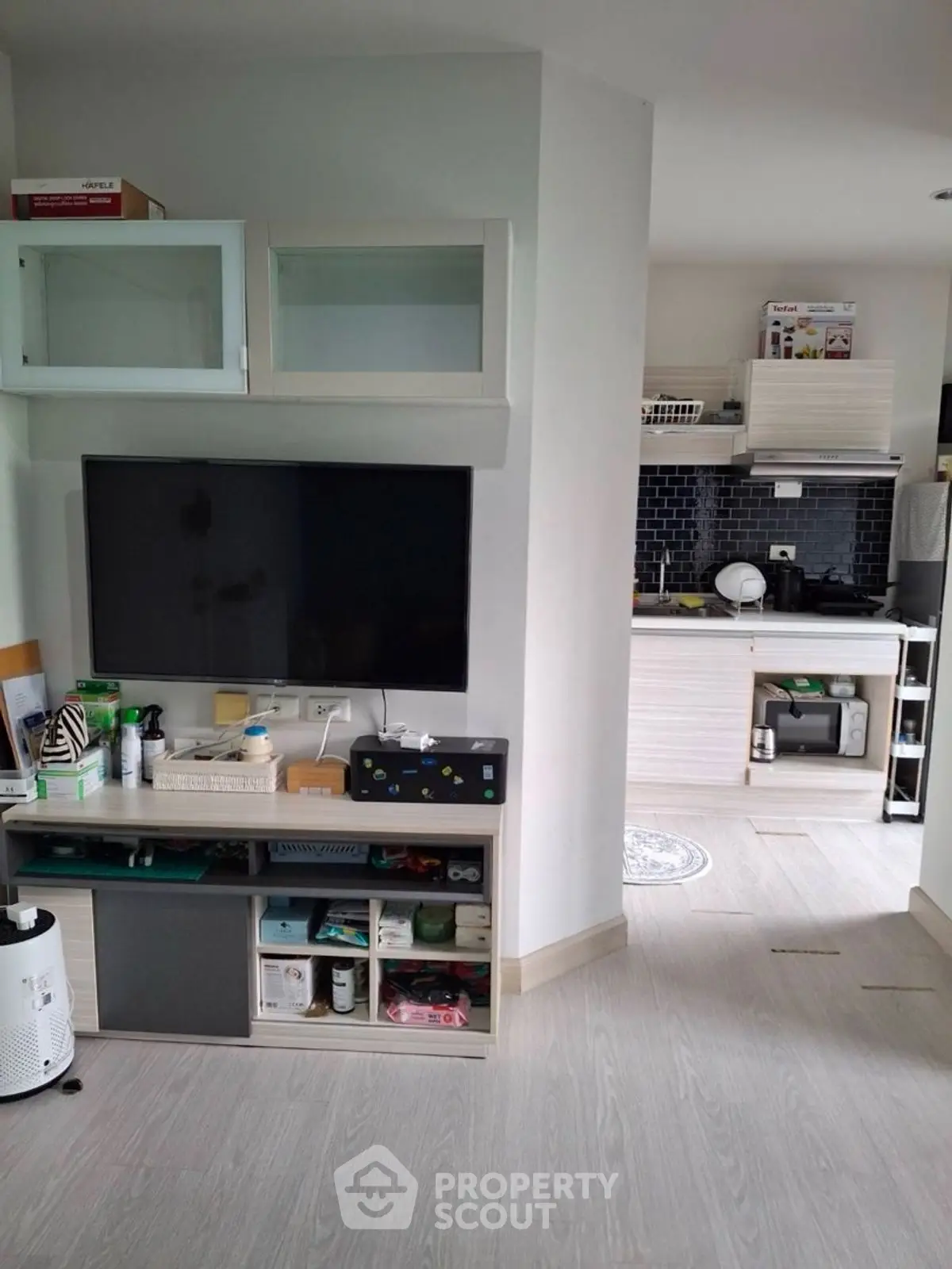 Modern open-layout living room with sleek kitchen and large TV