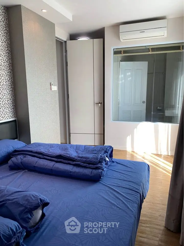 Modern bedroom with blue bedding and natural light