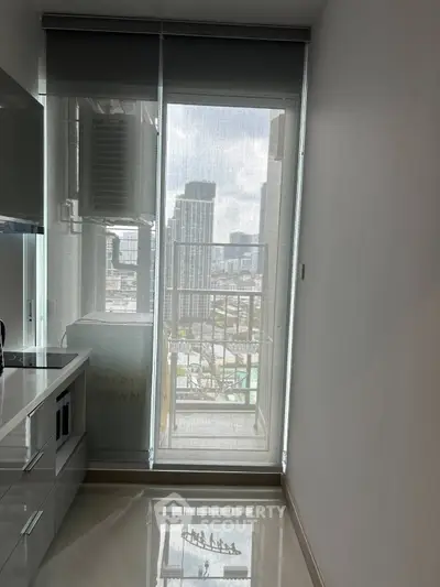 Modern kitchen with sleek cabinetry and city view from balcony