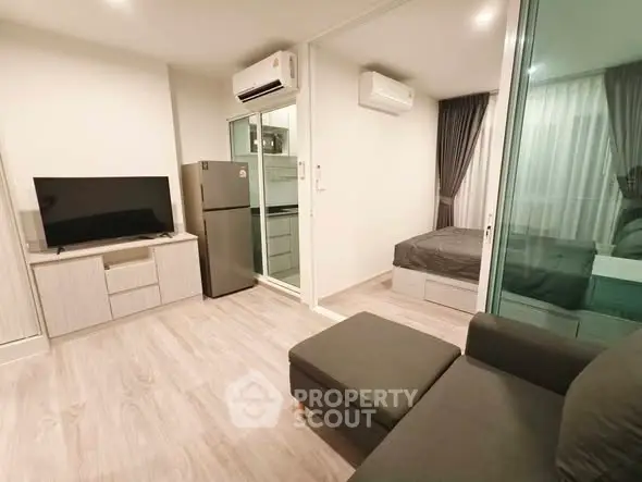 Modern apartment interior with living room and bedroom, featuring sleek furniture and air conditioning.