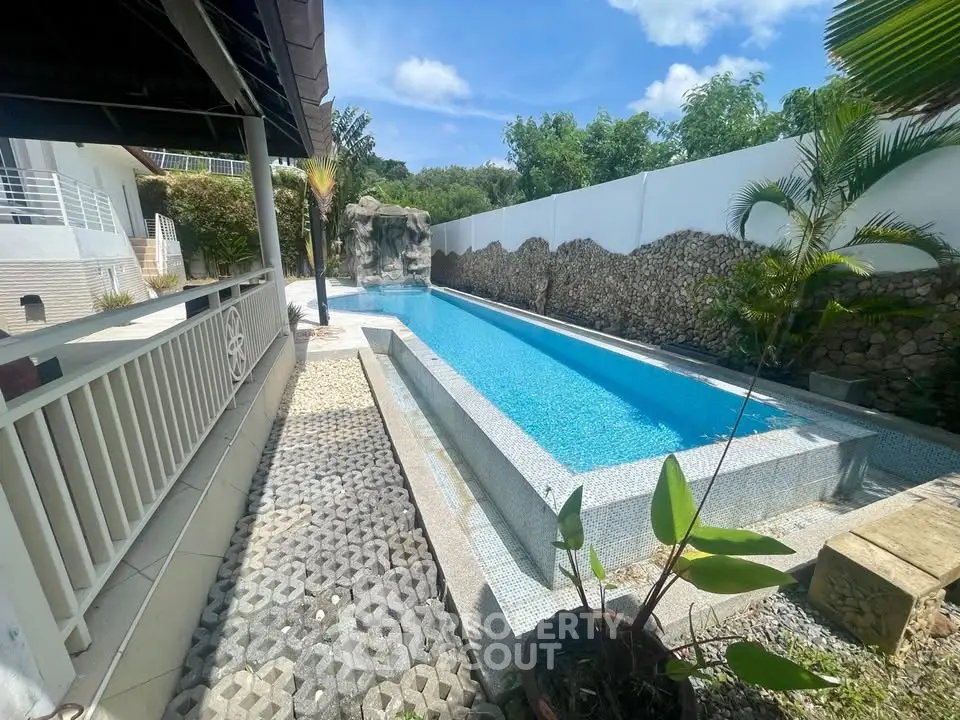 Luxurious outdoor pool with modern design and lush greenery, perfect for relaxation and entertainment.