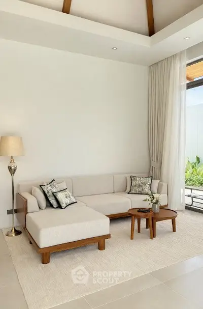 Elegant living room with modern furniture and large window offering natural light.