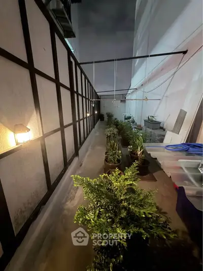 Charming outdoor garden space with lush greenery and ambient lighting, perfect for relaxation and entertaining.