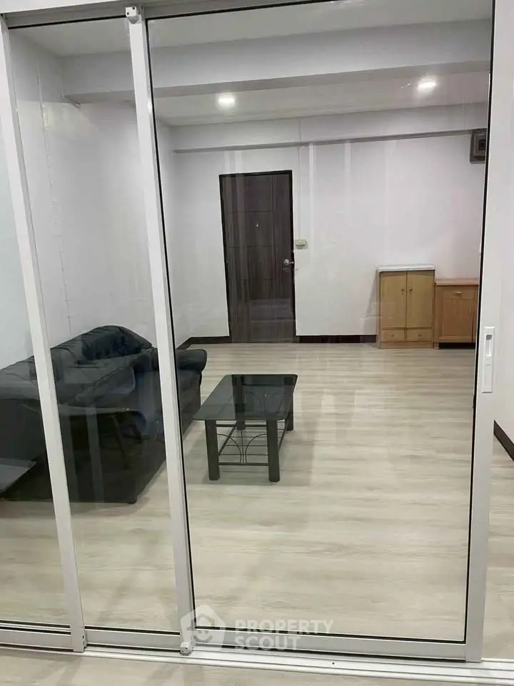 Spacious living room with modern glass sliding doors and minimalist furniture.