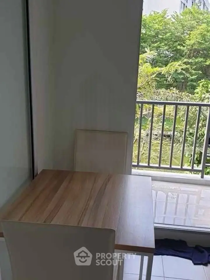 Cozy dining area with natural light and balcony view in modern apartment.