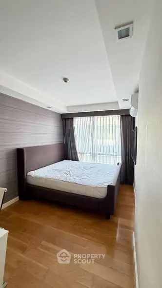 Spacious bedroom with modern design and large window for natural light