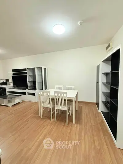 Spacious modern living room with elegant dining set and sleek storage units.
