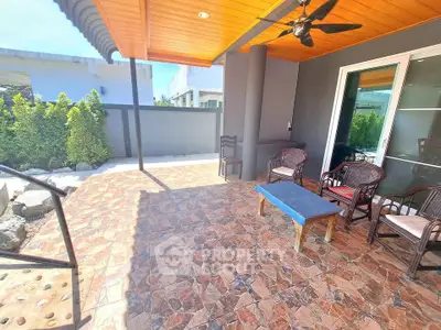 Spacious outdoor patio with stylish stone flooring and cozy seating area, perfect for relaxation.