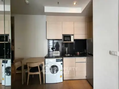 Modern kitchen with washing machine and dining area in stylish apartment