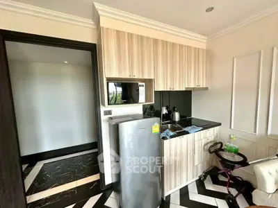 Modern compact kitchen with sleek cabinetry and appliances in a stylish apartment.