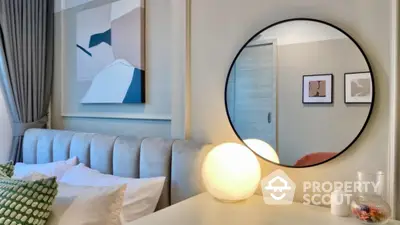 Stylish bedroom with modern decor and round mirror