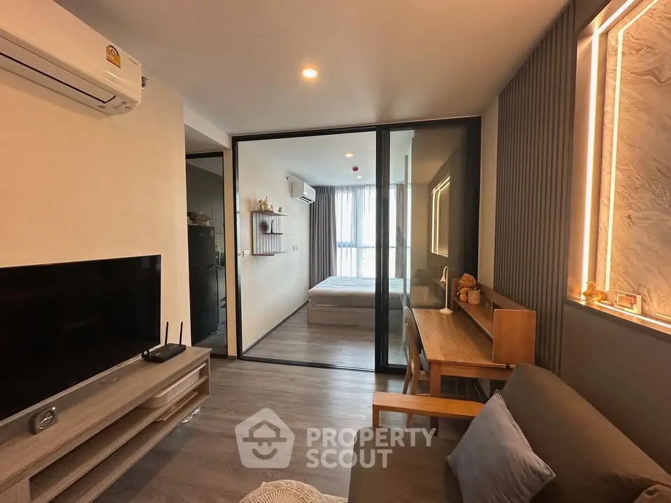 Modern living room with glass partition and stylish furniture in a cozy apartment.