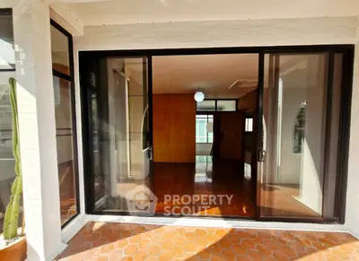 Spacious room with sliding glass doors and wooden flooring, ideal for modern living.