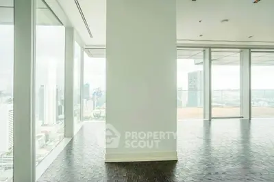 Spacious modern apartment with floor-to-ceiling windows offering stunning city views.