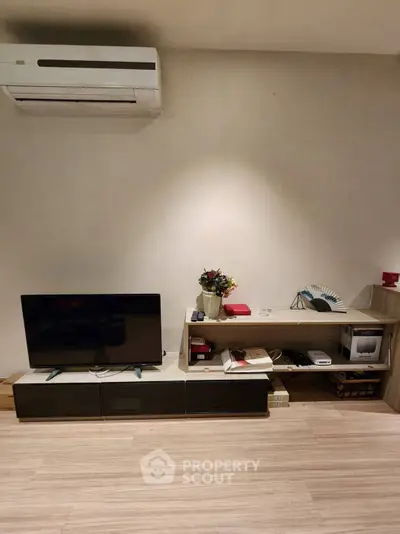 Modern living room with sleek TV setup and air conditioning unit