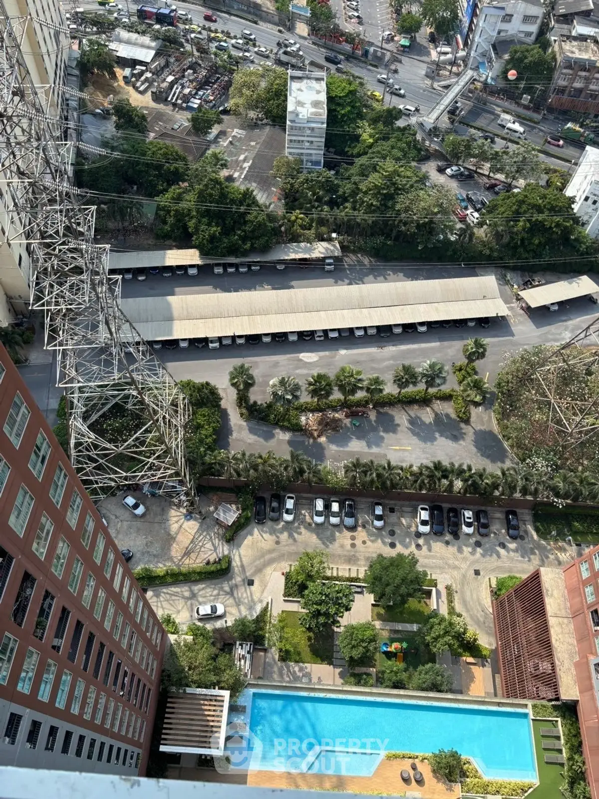 High-rise building view with pool and parking area, showcasing urban landscape and city streets.