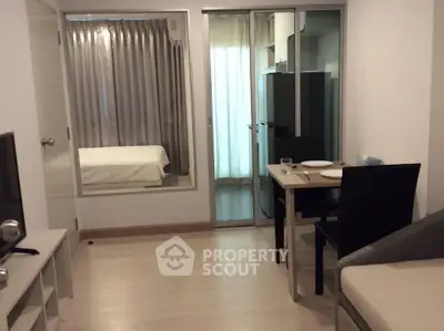 Modern apartment interior with open layout, featuring a cozy dining area and a glimpse into the bedroom.