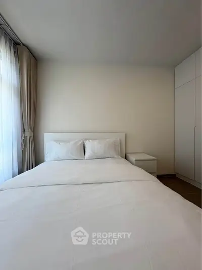 Spacious bedroom with minimalist design and ample natural light