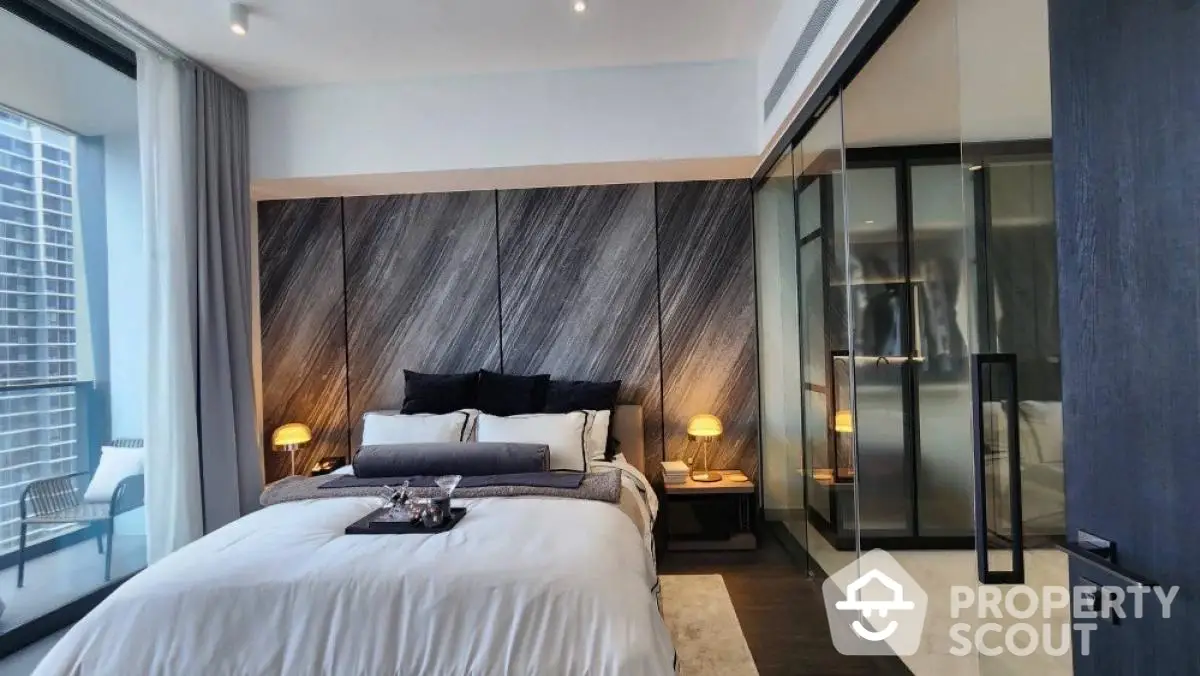 Luxurious modern bedroom with elegant decor and city view balcony access.