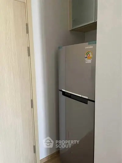 Compact kitchen corner with modern Samsung fridge in sleek design.