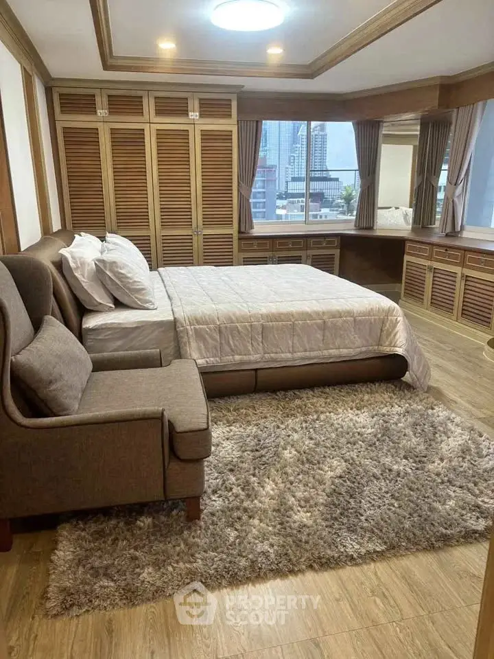 Luxurious bedroom with city view, featuring elegant wooden accents and plush furnishings.